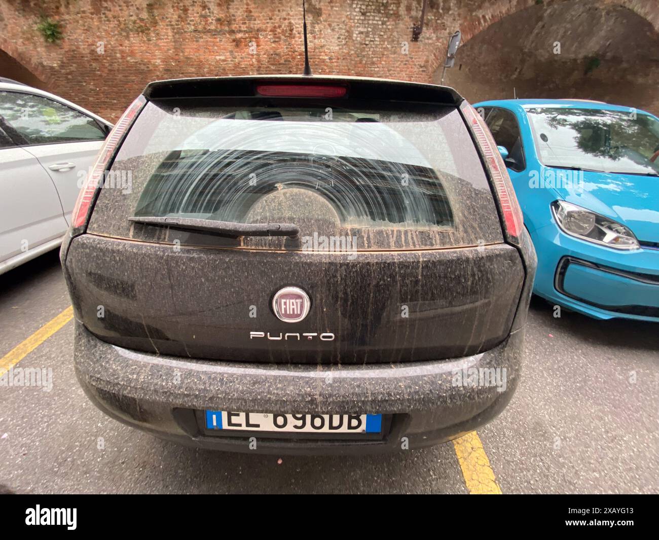 Cremona, Italie - 9 juin 2024 voiture noire poussiéreuse dans la ville a besoin d'être nettoyée, ressemblant à une tempête de sable du désert avec des teintes grises, brunes et blanches contre le Banque D'Images