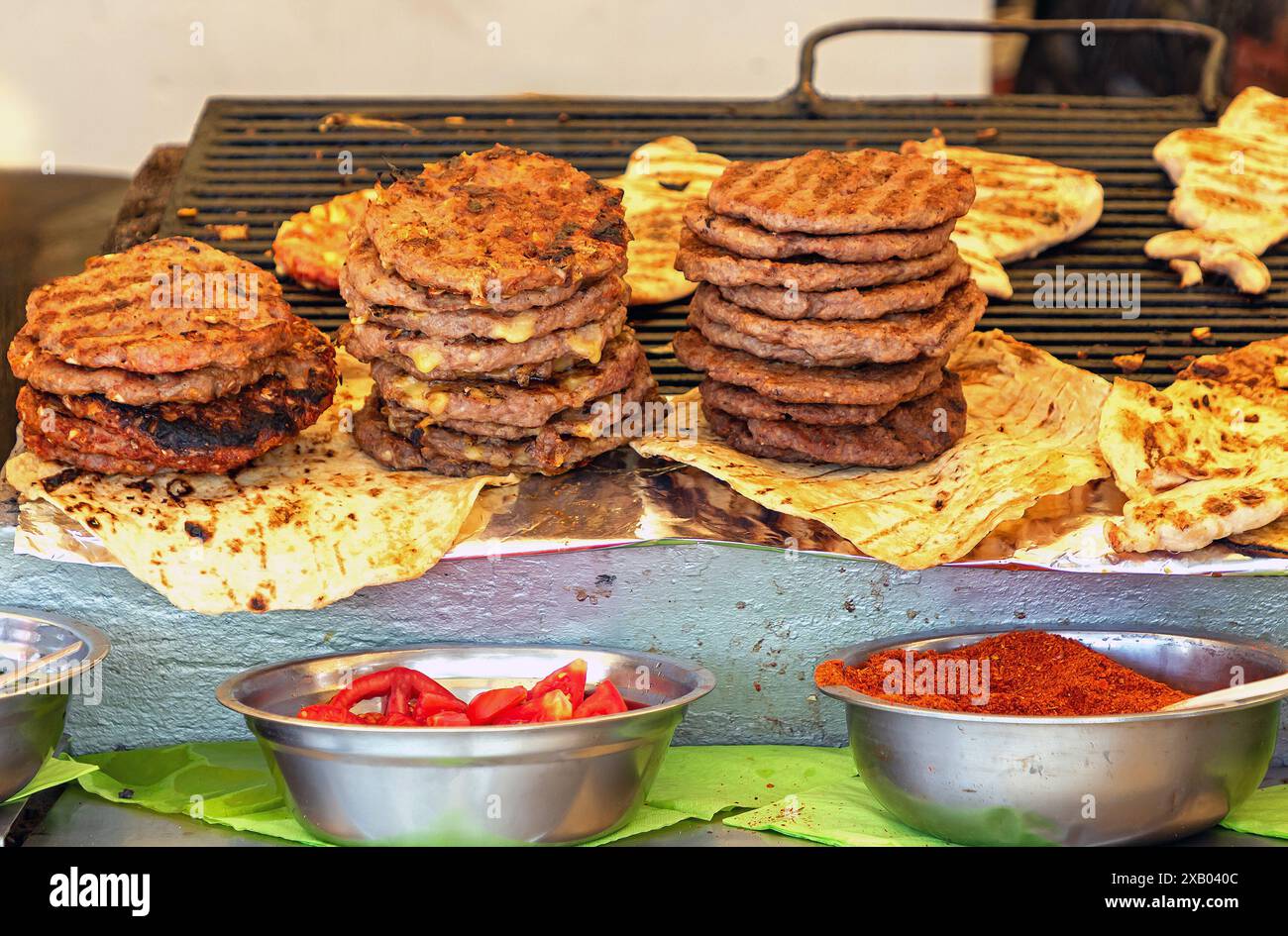 Hamburgers sur gril avec paprika et autres condiments vendus sur un étal de marché Banque D'Images