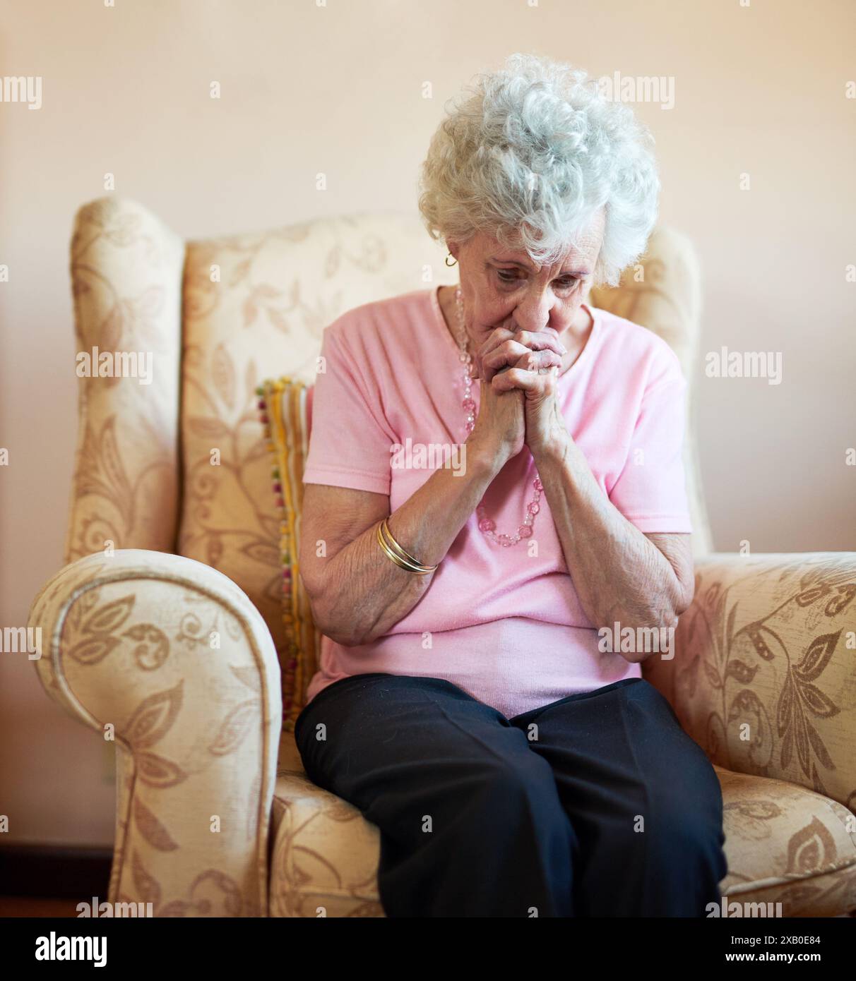 Femme aînée, louange et prie à la maison avec douleur pour saluer marie, Dieu et Jésus Christ ou le ciel. Vieille dame, religion et culte pour la foi Banque D'Images