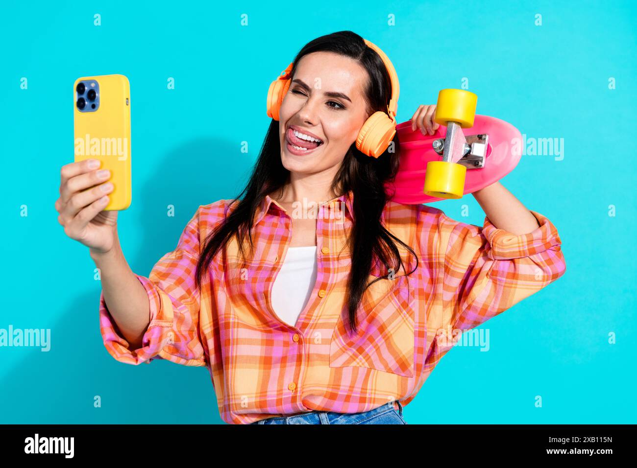 Portrait photo de jeune femme séduisante skater selfie habillé vêtements à carreaux élégants isolés sur fond de couleur aigue-marine Banque D'Images