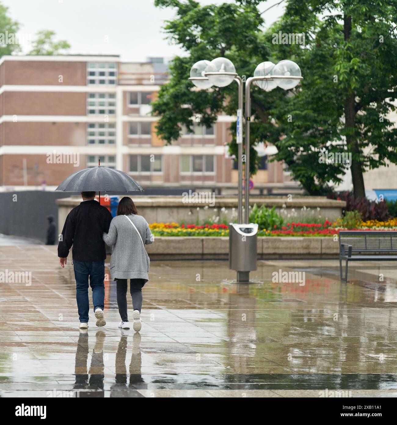 Jeune couple sous la pluie dans le centre-ville de Cologne en Allemagne Banque D'Images