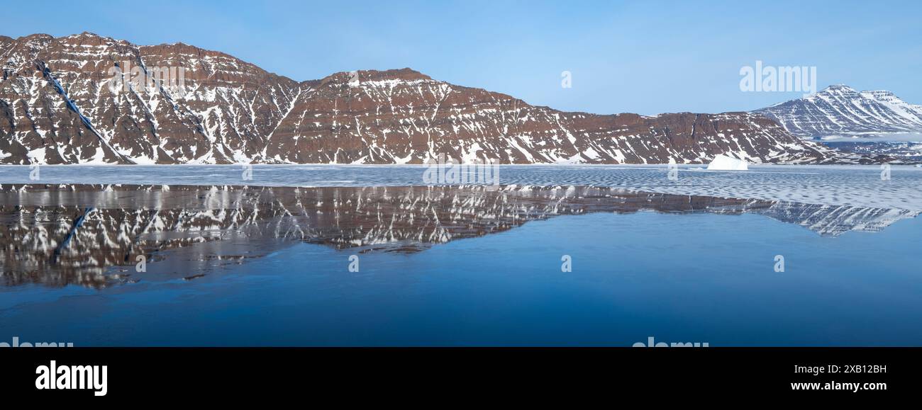 East Greenalnd, Blosseville Coast. Tôt le matin, reflets gelés de fjord, avec iceberg. Banque D'Images