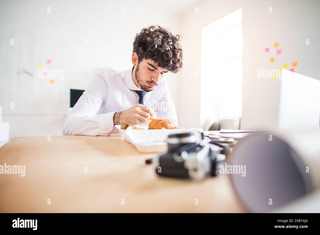 Homme d'affaires ayant un déjeuner rapide, repas fastfood dans le bureau de la société de démarrage. Banque D'Images