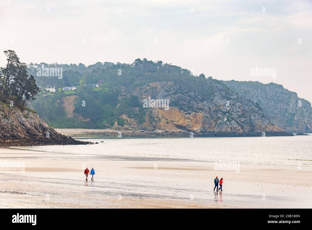 Côte rocheuse avec des gens marchant sur la plage Banque D'Images