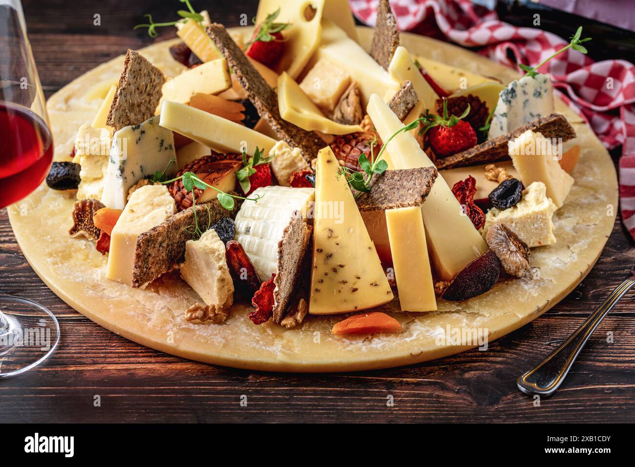 Assiette de fromage préparée avec des fromages de luxe et du vin sur une table en bois Banque D'Images