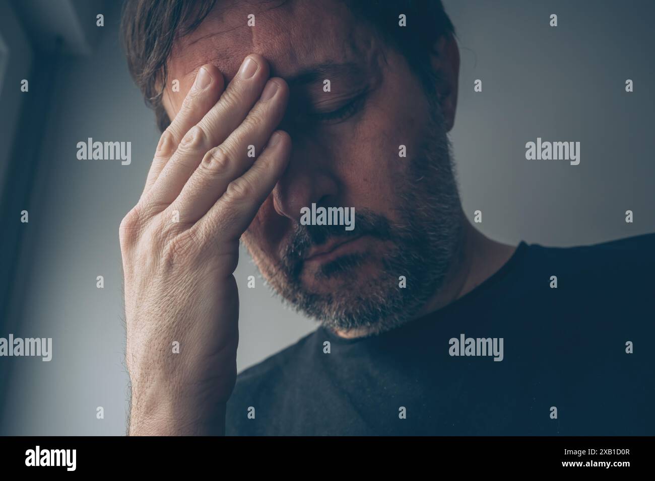 Homme désespéré déçu dans l'intérieur de la chambre sombre, mise au point sélective Banque D'Images