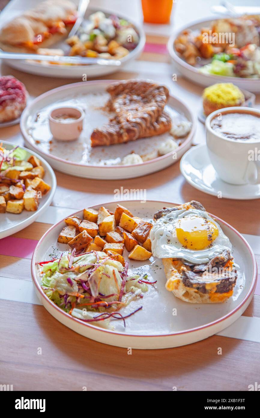 Table de petit déjeuner avec plats et boissons variés. Banque D'Images