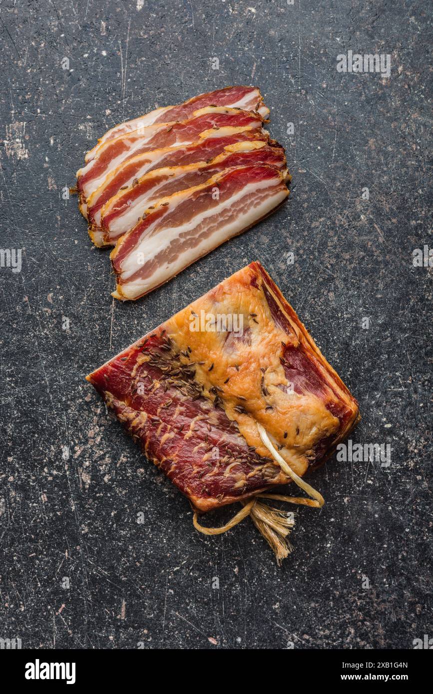 Gros plan de tranches de bacon fumé sur une table noire. Vue de dessus. Banque D'Images