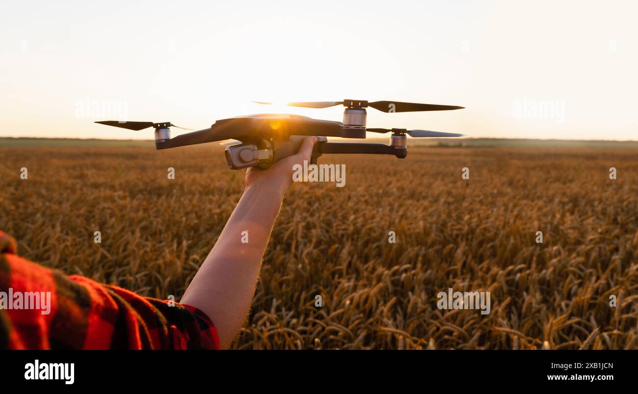 Agriculteur avec drone sur un champ de blé. Agriculture intelligente et agriculture de précision Banque D'Images