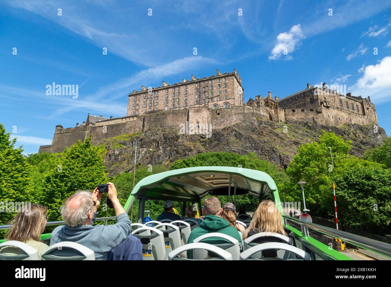 Groupe de touristes appréciant la visite en bus à toit ouvert d'Édimbourg, en passant par le château d'Édimbourg Banque D'Images