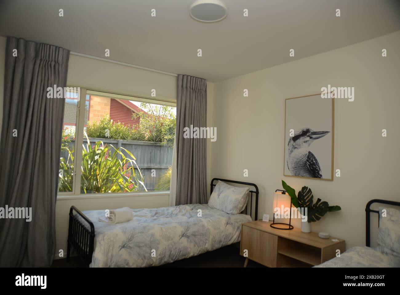 CHRISTCHURCH, NOUVELLE-ZÉLANDE, 27 FÉVRIER 2023 : intérieur d'une chambre moderne avec deux lits simples, chevets et design intérieur élégant. Banque D'Images