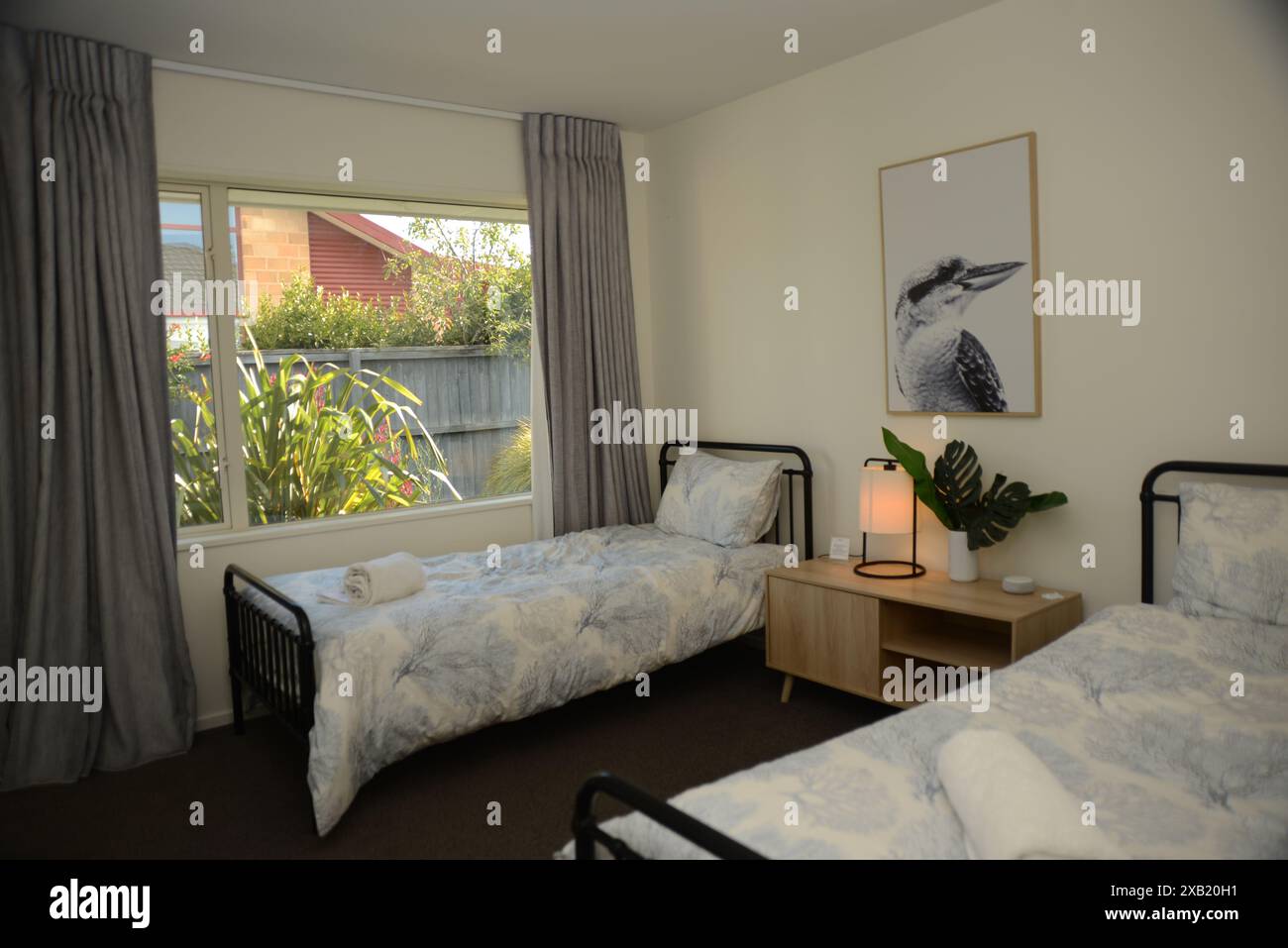 CHRISTCHURCH, NOUVELLE-ZÉLANDE, 27 FÉVRIER 2023 : intérieur d'une chambre moderne avec deux lits simples, chevets et design intérieur élégant. Banque D'Images