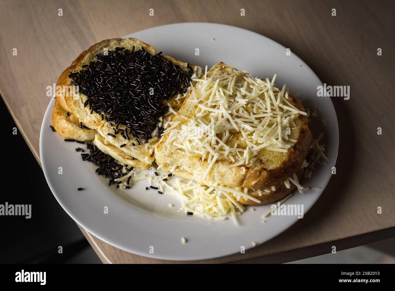 Pain grillé avec des saupoudrées de chocolat et fromage râpé dans une ambiance sombre, un concept pour une collation de minuit Banque D'Images