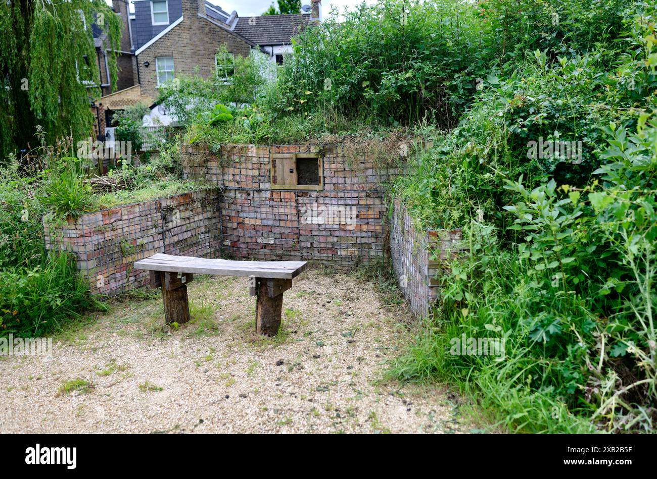 Banc dans la réserve naturelle de Northcote avec des maisons behinf, Isleworth, Londres, Angleterre Banque D'Images