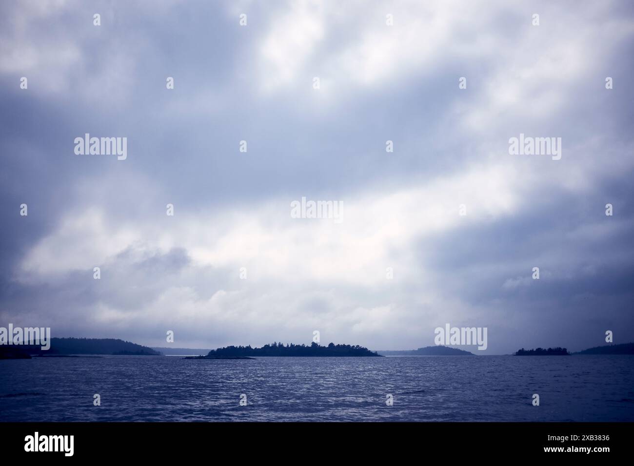 Mer sous ciel nuageux au coucher du soleil Banque D'Images