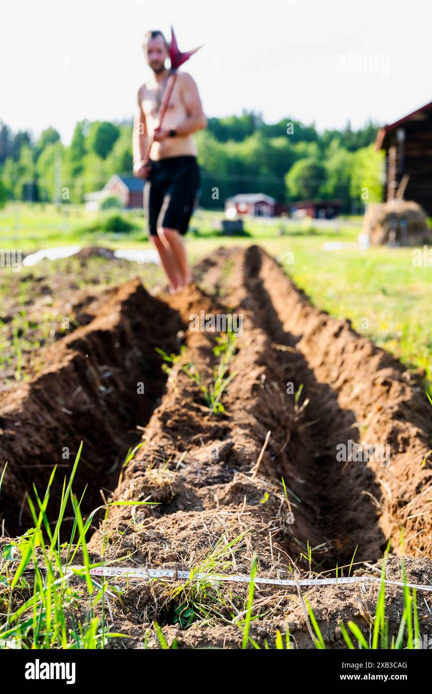 Agriculteur masculin travaillant dans la ferme le jour ensoleillé Banque D'Images