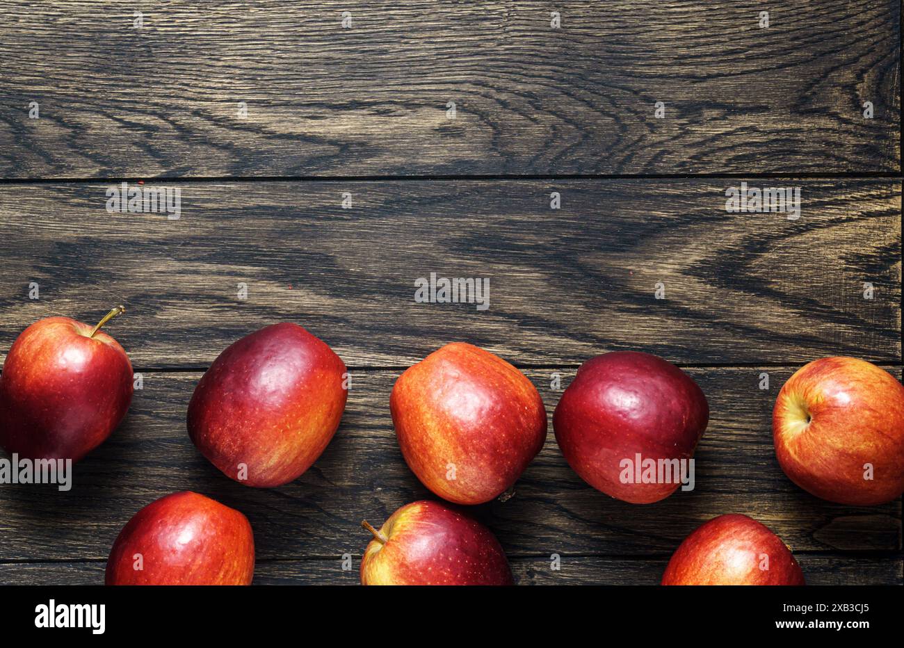 Vue en angle élevé de pommes rouges mûres sur fond de chêne rustique, vue de dessus avec espace de copie Banque D'Images