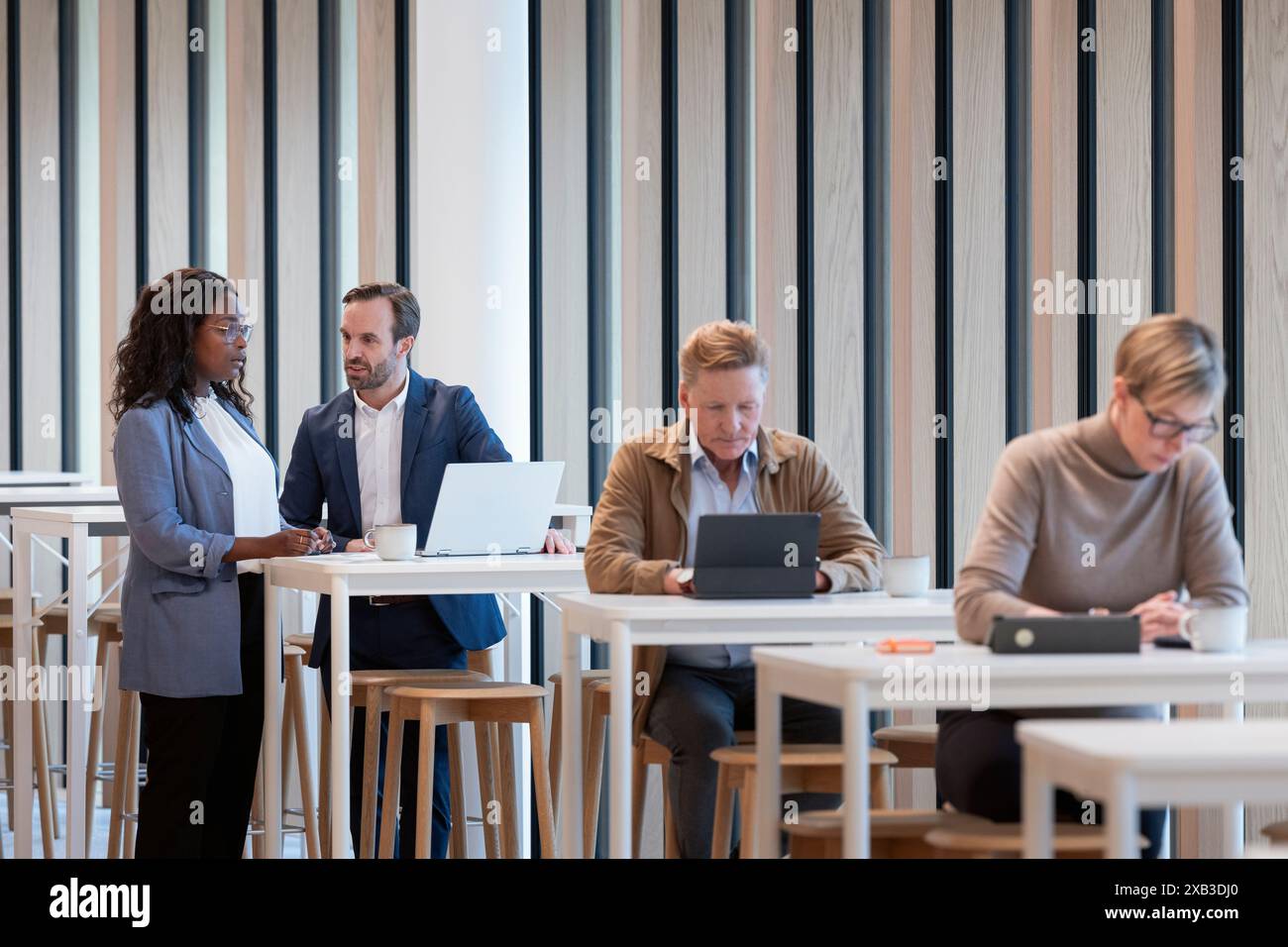 Collègues masculins et féminins multiraciaux à table dans la cafétéria du bureau Banque D'Images