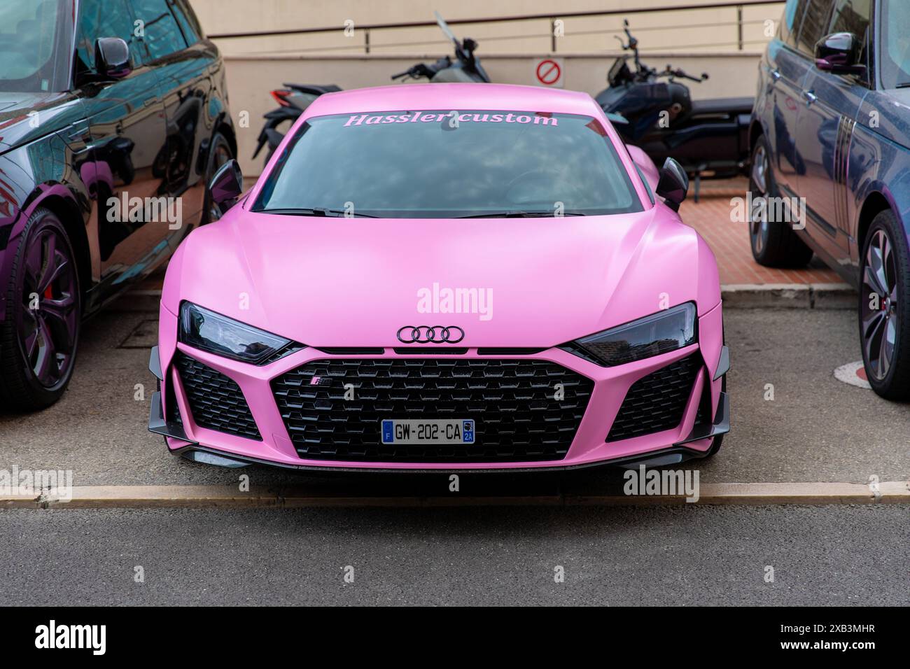 Monte-Carlo, Monaco - 9 juin 2024 : une Audi R8 rose frappante, personnalisée par Hassler Custom, stationnée dans une zone de voitures de luxe. Ce sport de haute performance c Banque D'Images