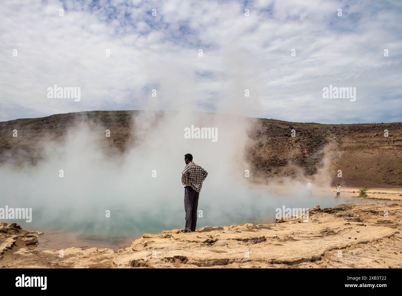 Guide touristique à Alolabad, en Éthiopie, montrant des sources naturelles volcaniques géothermiques chaudes avec piscine vapeur et petits lacs colorés, geysers et criques Banque D'Images