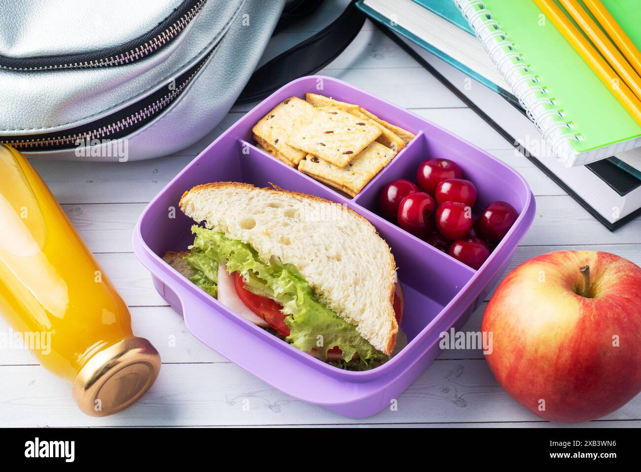 Délicieux sandwich sain dans une boîte à lunch, biscuits et cerises. Emportez le déjeuner avec vous à l'école ou au bureau, jus dans une bouteille et une pomme Banque D'Images Délicieux sandwich sain dans une boîte à lunch, biscuits et cerises. Emportez le déjeuner avec vous à l'école ou au bureau, jus dans une bouteille et une pomme Banque D'Images