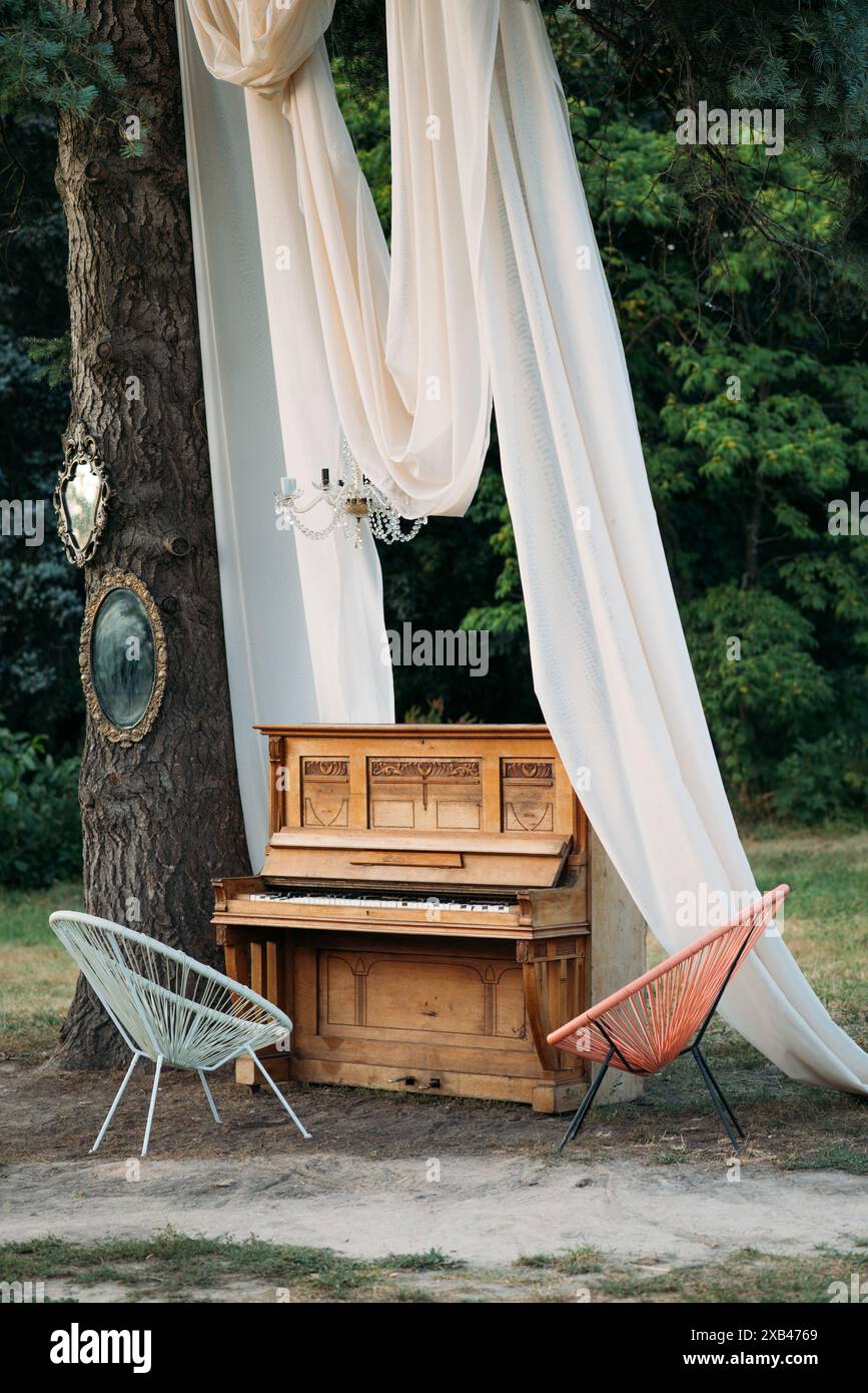 piano et chaise avec décor romantique en été dans le jardin. Décor pour un mariage ou un dîner romantique Banque D'Images