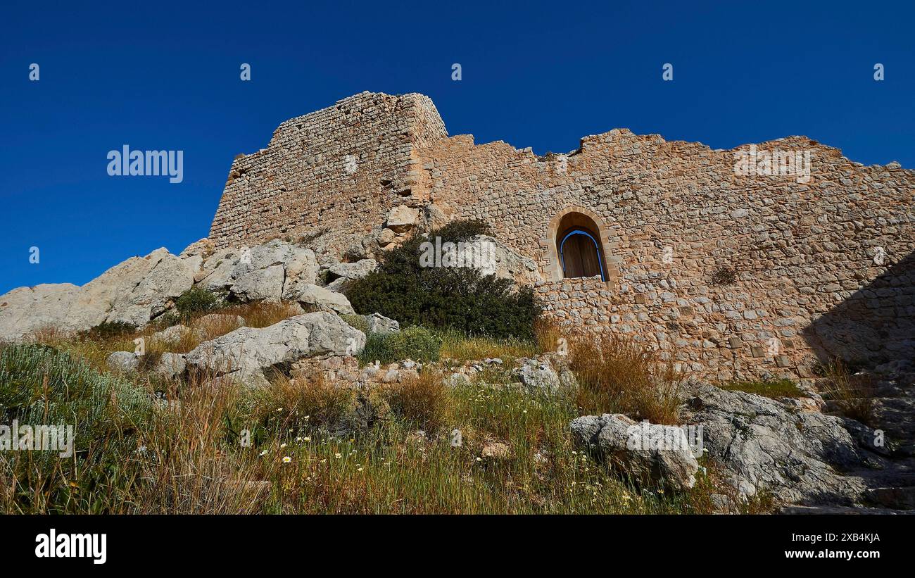 Ruines d'un château avec des murs partiellement conservés et une fenêtre, entouré de végétation sous un ciel clair, château de Kritinia, château de St Jean Banque D'Images