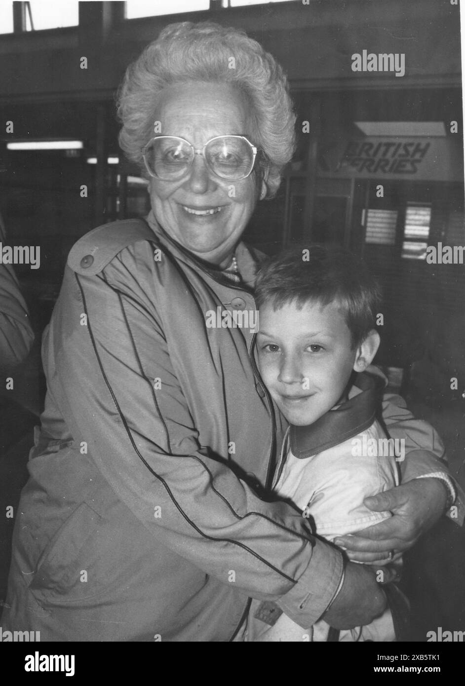 BETTY ELLEY EMBRASSE SON PETIT-FILS LORSQU'ILS ARRIVENT À BORD DU BRITTANY FERRIES CROSS CHANNEL FERRY REINE MATILDE QUI A ÉTÉ REMORQUÉ À PORTSMOUTH APRÈS QU'UN INCENDIE A ÉCLATÉ DANS LA SALLE DES MACHINES DU NAVIRE, 1990 PIC MIKE WALKER 1990 Banque D'Images