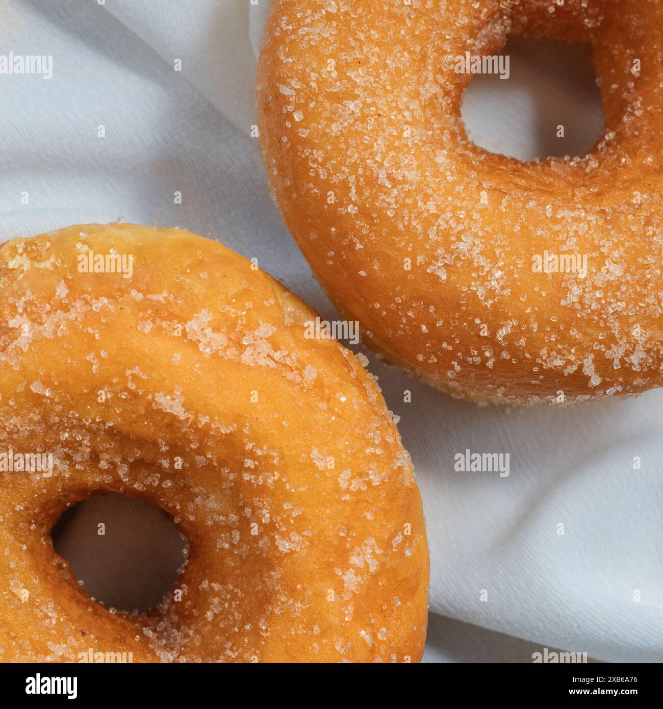 Gros plan de deux beignets de sucre vanillé sur une nappe blanche, pas de gens Banque D'Images
