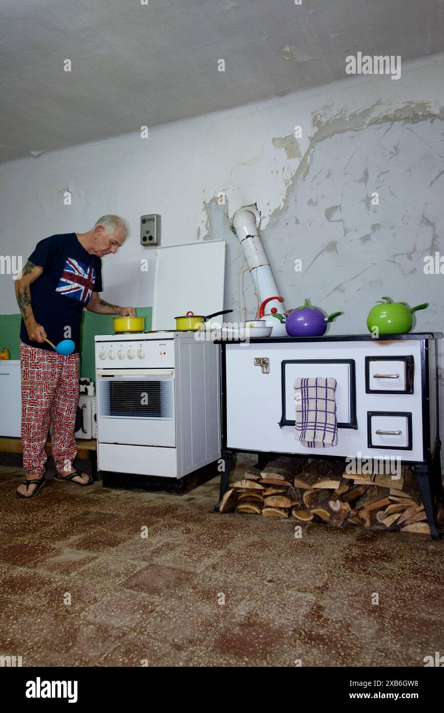 expatrié britannique masculin mature dans des vêtements appropriés repas de cuisine dans sa cuisine pour ses collègues expatriés zala comté hongrie Banque D'Images