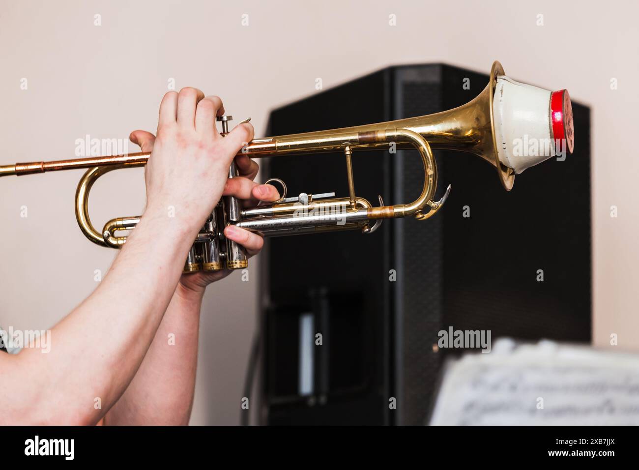 Trompette avec sourdine droite dans les mains du trompettiste. Photo de fond de musique live Banque D'Images