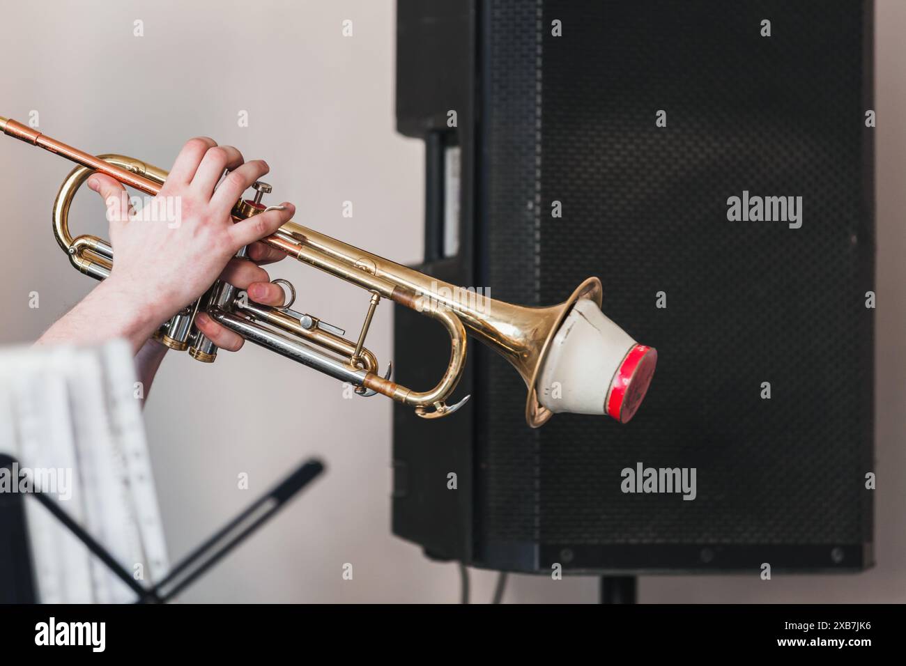 Trompette avec sourdine droite dans les mains du trompettiste. Photo de fond de musique live Banque D'Images