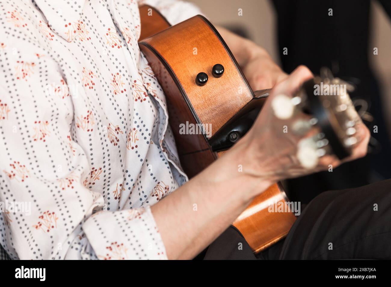 Mains d'un joueur de guitare acoustique, photo en gros plan avec mise au point sélective. Fond de musique live Banque D'Images