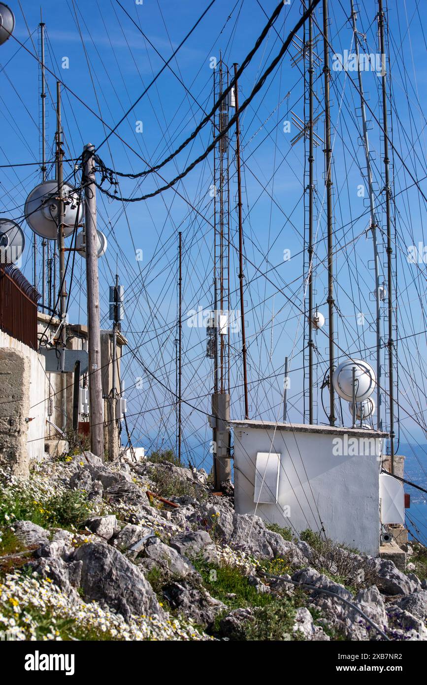 Plusieurs poteaux téléphoniques bordent une falaise océanique avec une clôture Banque D'Images