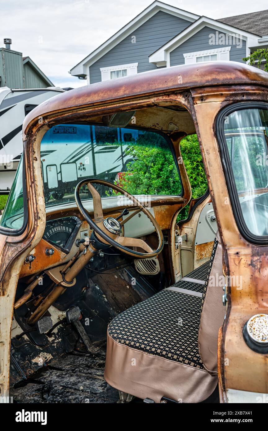 Une camionnette rouillée vintage garée devant une maison rustique Banque D'Images