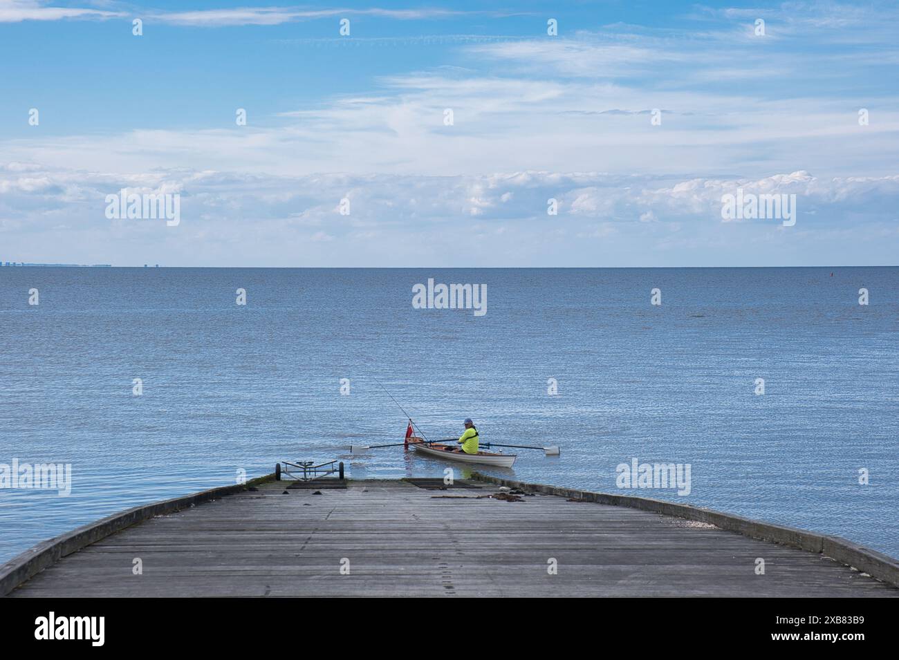 Rameur solitaire dans son bateau à Whitstable, Kent au début du printemps Banque D'Images