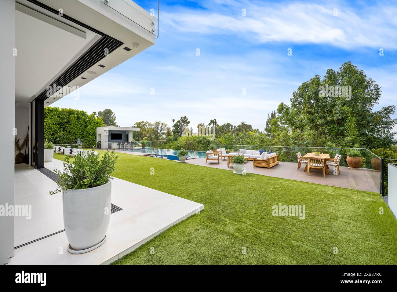 Un patio de luxe avec pelouse et une salle à manger en bois Banque D'Images
