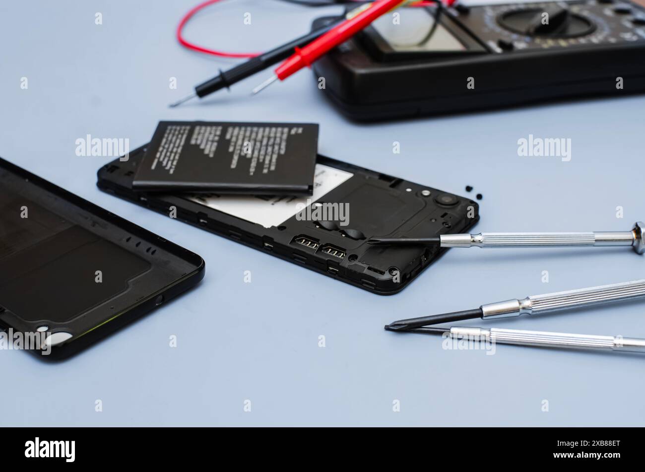 Smartphone démonté, processus de remplacement de la batterie. Le couvercle arrière du smartphone a été retiré, révélant la batterie et les composants internes Banque D'Images