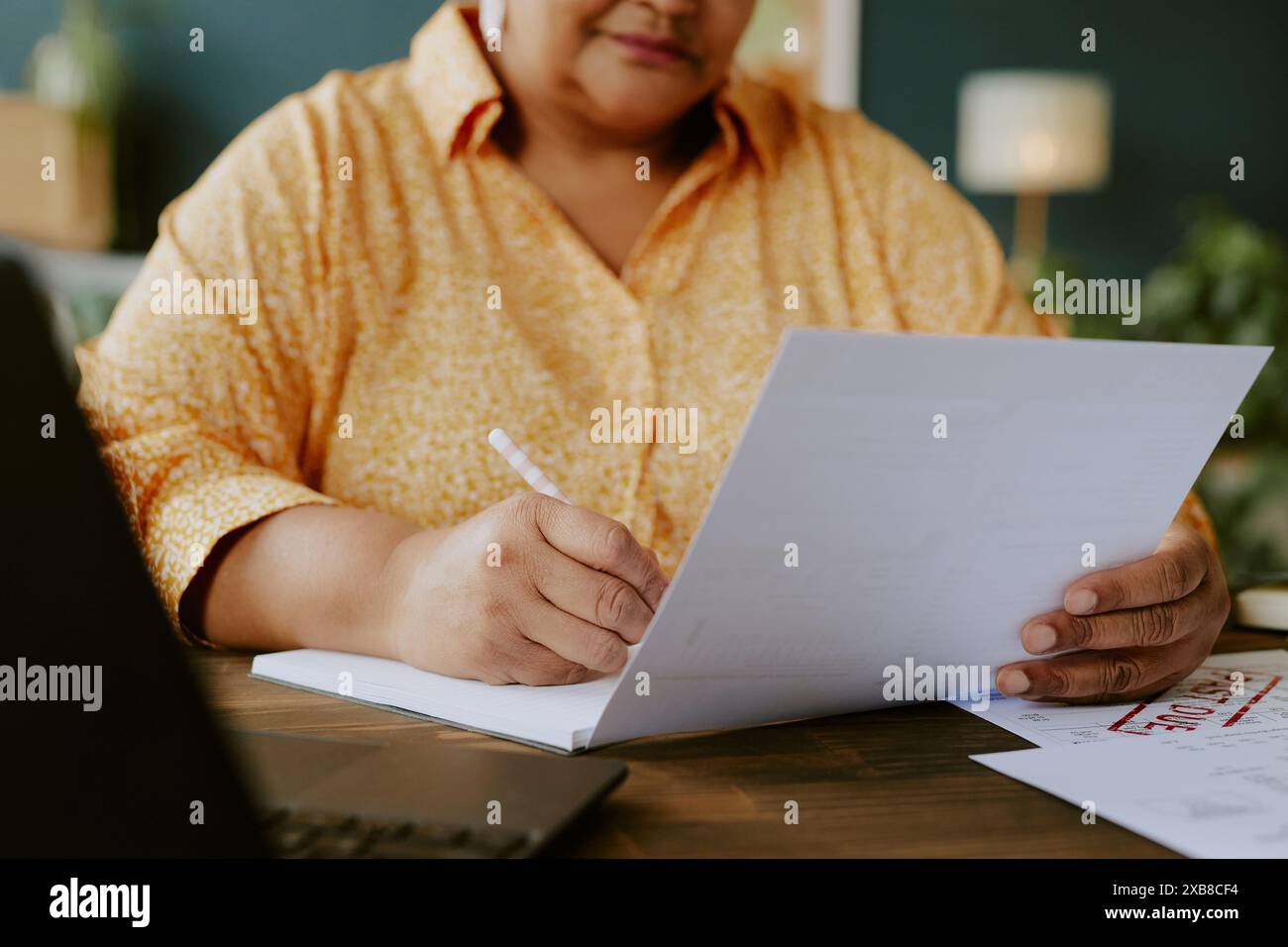 Gros plan de mains féminines afro-américaines seniors tenant un stylo et des documents. Elle remplit le formulaire Banque D'Images