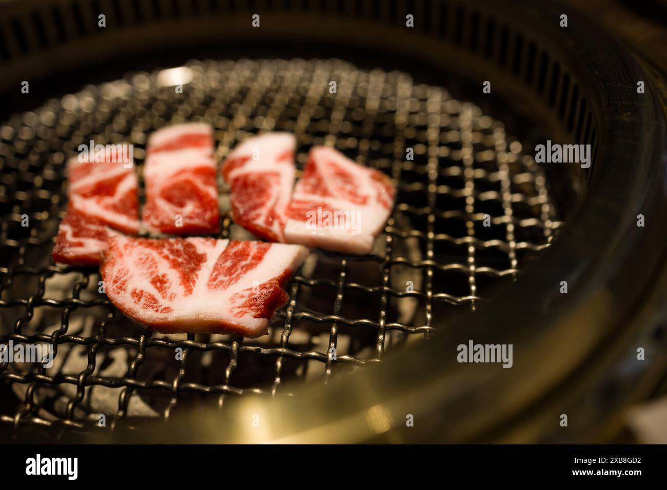 La viande crue placée sur un tas de charbon de bois Banque D'Images