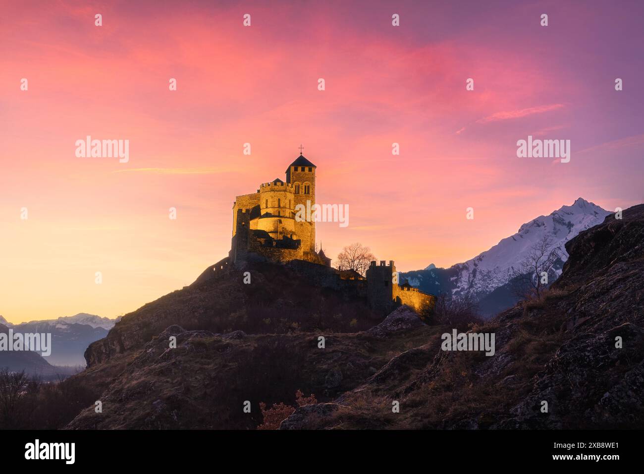 Une belle vue sur la basilique Valère à Sion au coucher du soleil avec des couleurs rose et orange Banque D'Images