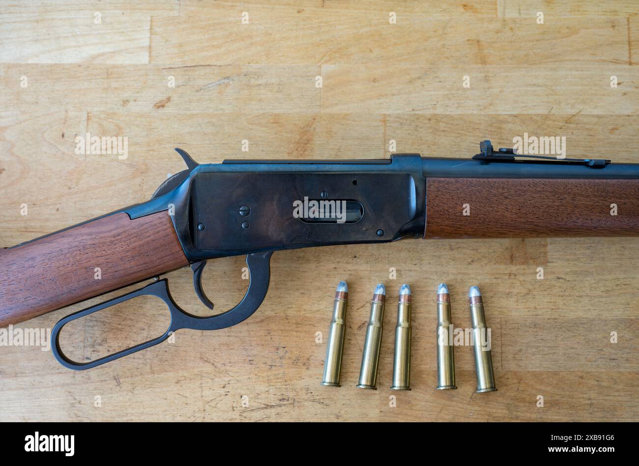 Détail d'un vieux fusil à levier winchester de l'extrême ouest et sauvage avec quelques balles de calibre 30-30 sur une table en bois Banque D'Images
