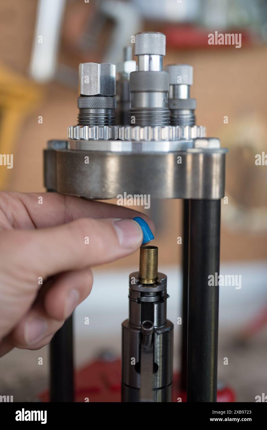 Procédé de rechargement de munitions à domicile. Détail du placement manuel et de l'introduction de la pointe du projectile de 9 mm avec la presse. Banque D'Images