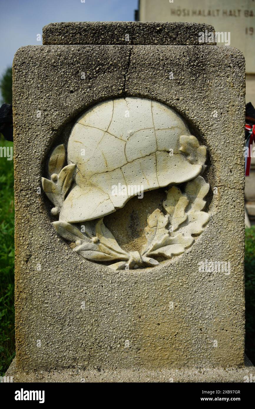 Monument en pierre avec un casque placé à côté d'une bouche d'incendie Banque D'Images