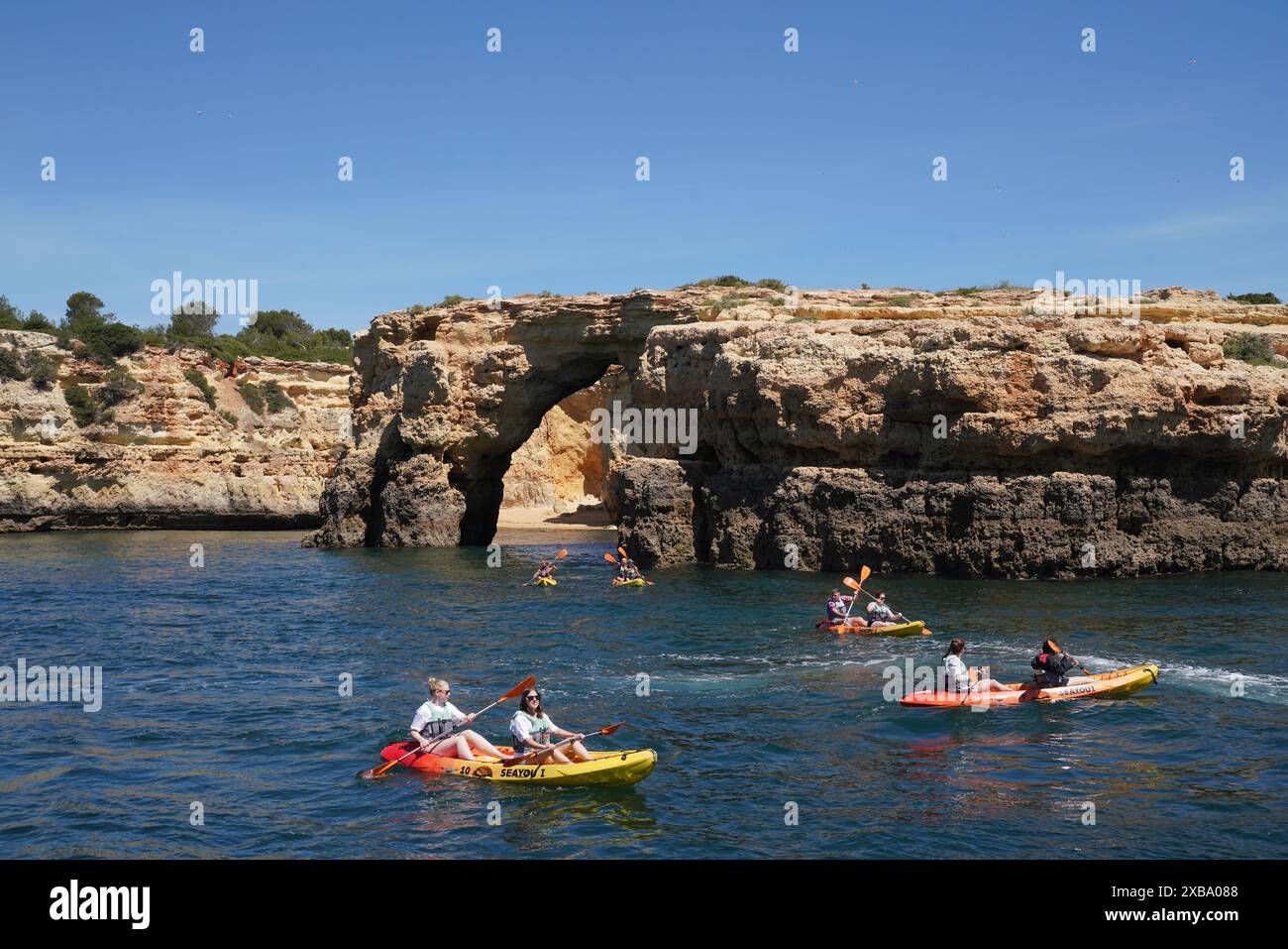 Kayakistes à Albandeira Arch à Praia de Albandeira sur la côte de l'Algarve au sud du Portugal. Banque D'Images