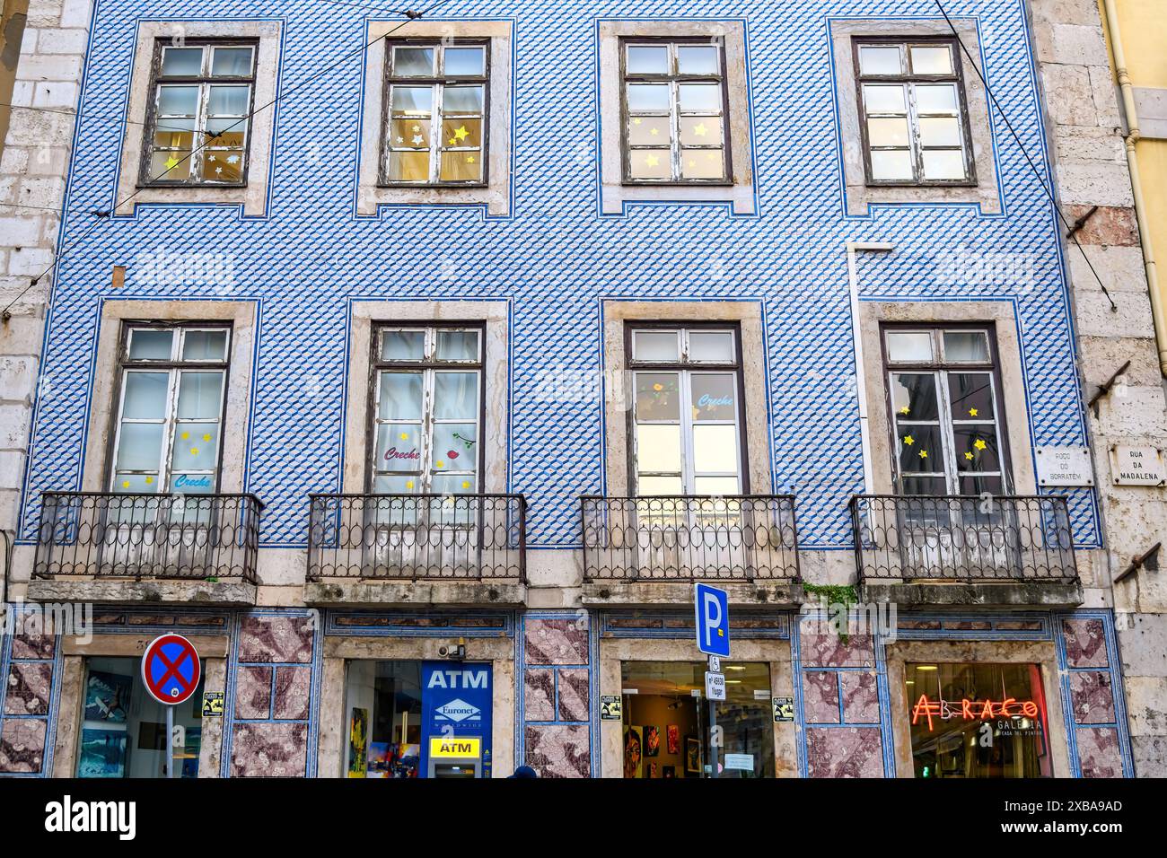 Façade d'un bâtiment recouverte de tuiles. Un signe d'ATM est vu à l'étage inférieur. Banque D'Images