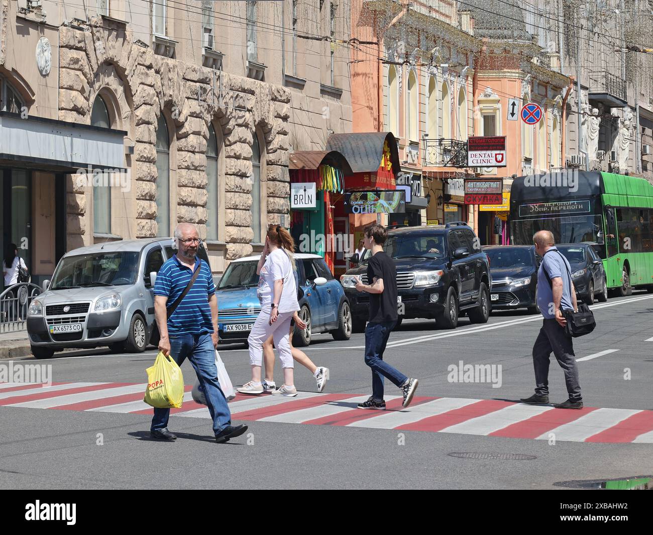 KHARKIV, UKRAINE - 8 JUIN 2024 - des gens traversent une rue à un passage à zèbre, Kharkiv, dans le nord-est de l'Ukraine. Banque D'Images