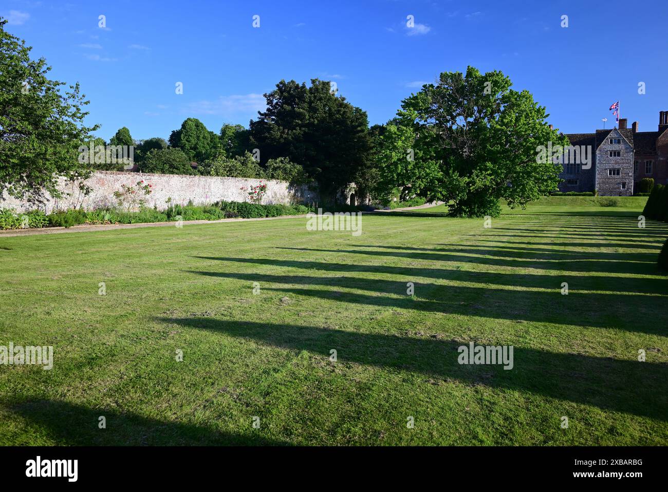 De longues ombres produites par le faible ensoleillement du soir dans le jardin arrière de Littlecote House, un hôtel Warner dans le Wiltshire. Banque D'Images