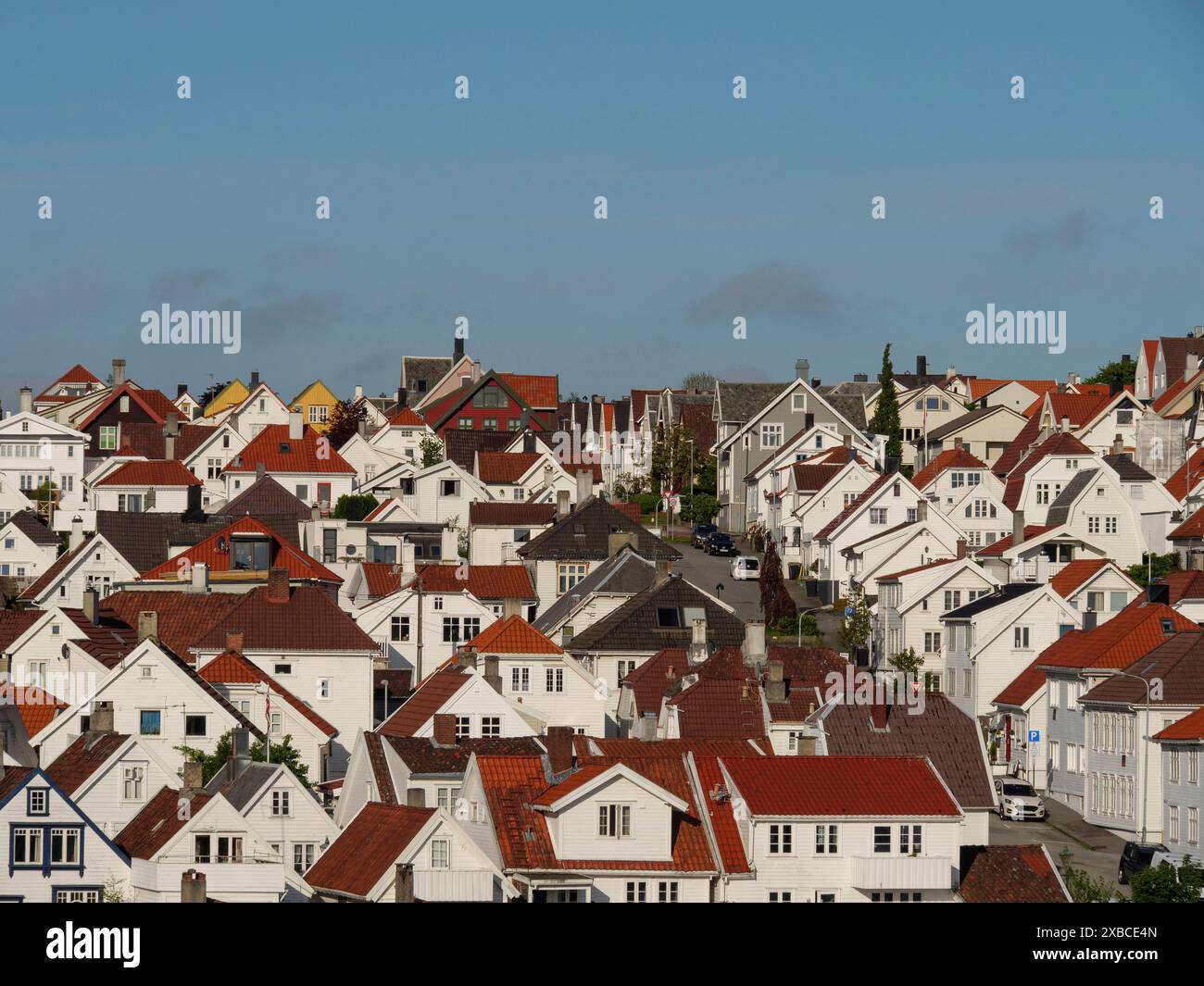 Dense cluster de maisons traditionnelles avec des toits rouges dans un village urbain sous un ciel clair, Stavanger, Norvège, Scandinavie Banque D'Images