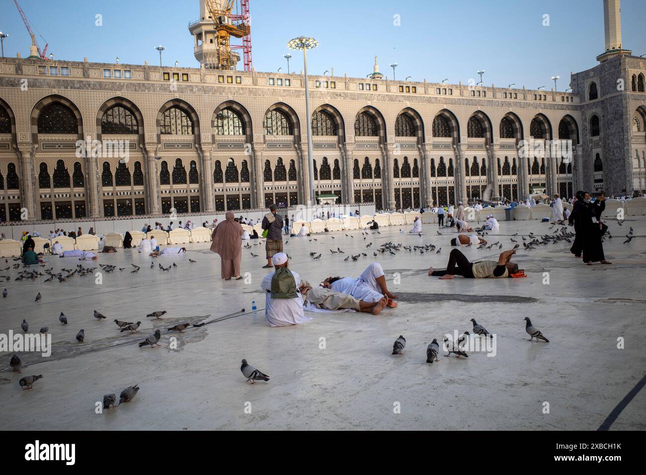 La Mecque, Arabie Saoudite - 1er juin 2024 : pèlerins du Hadj et de l'Umrah assis et couchés près de Masjidil Haram, Grande Mosquée de la Mecque avec de nombreuses colombes. Hajj 2024. Banque D'Images